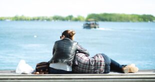 couple having rest on river embankment