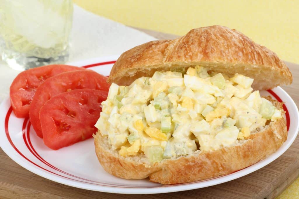 Sanduíche de salada de ovo com fatias de tomate em um prato