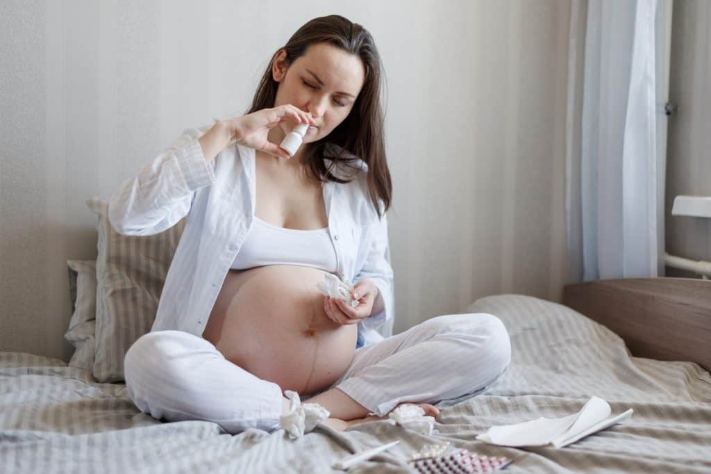 mulher grávida usando spray nasal de xilitol