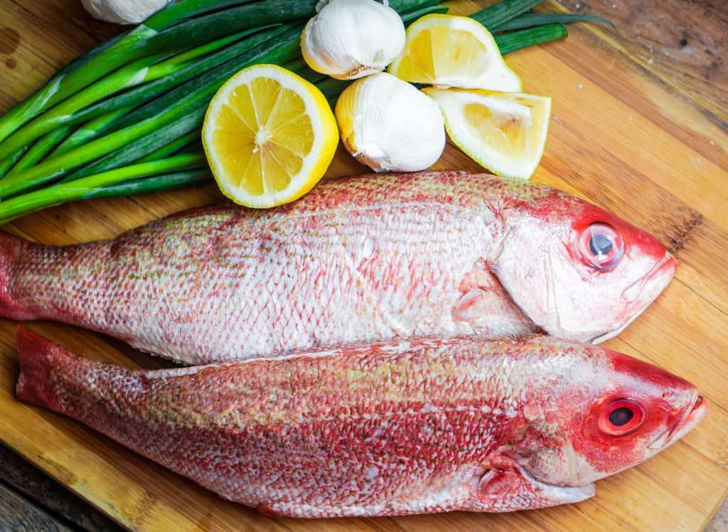 pargo fresco com limão e alho em uma tábua