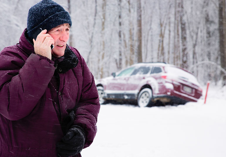 Homem pedindo ajuda depois que seu carro sai da estrada durante a condução no inverno