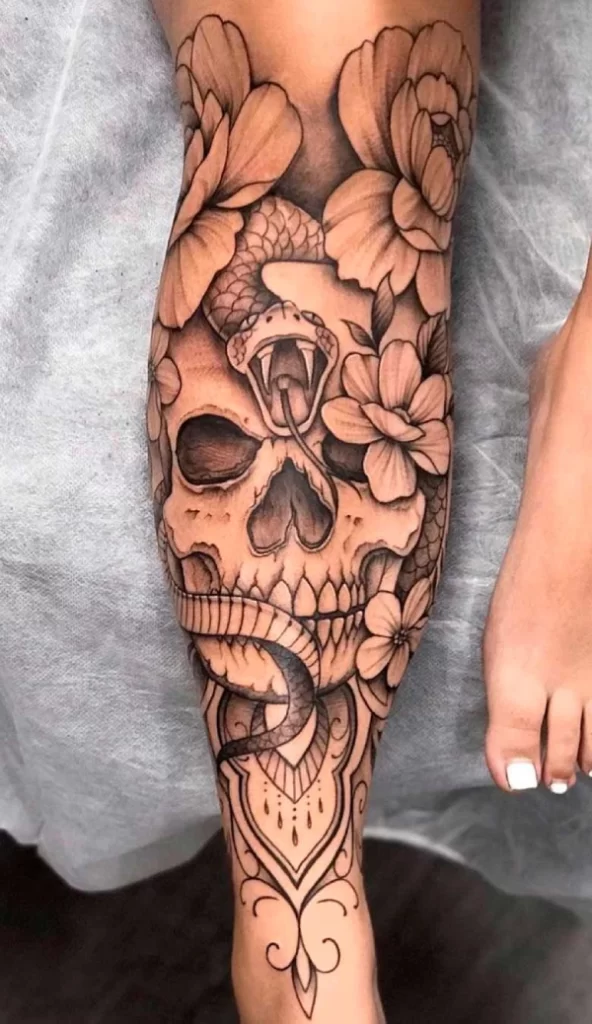 tatuagem de caveira com flores nas pernas