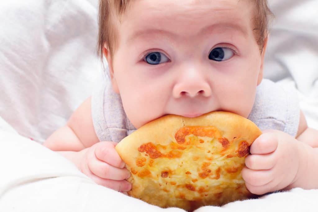 um bebê comendo pizza