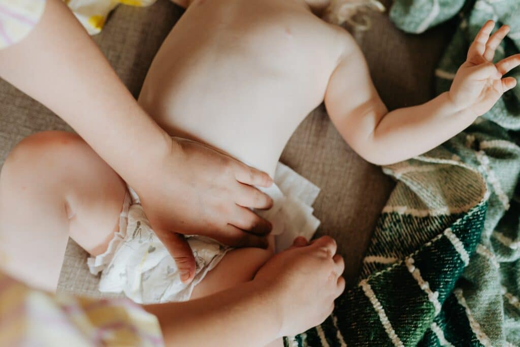 Cuidador trocando a fralda de um bebê